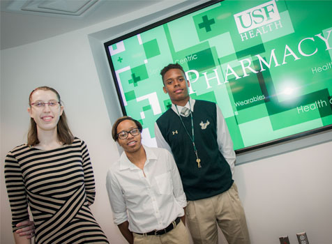 Three student interns from the USF Healht College of Pharmacy smile